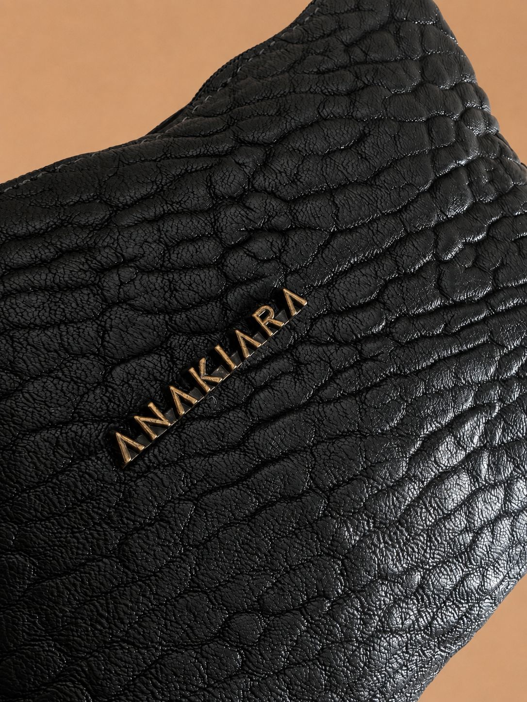 Lina bubble noir — détail du cuir bubble et de la signature dorée